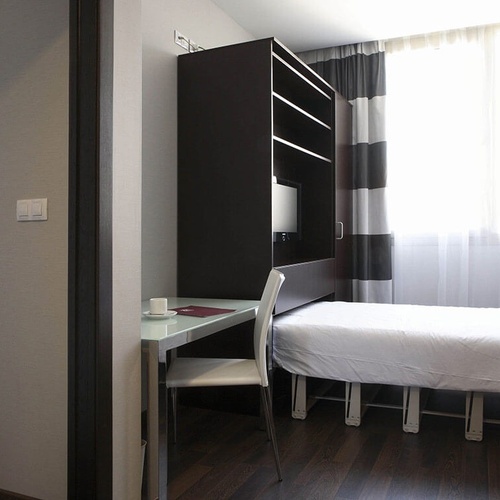 una habitación de hotel con una cama y una mesa