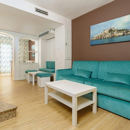 una sala de estar con un sofá azul y una mesa blanca