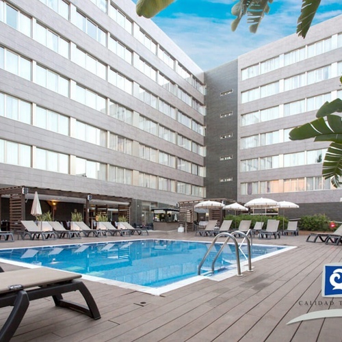 una piscina rodeada de sillas y sombrillas en un hotel