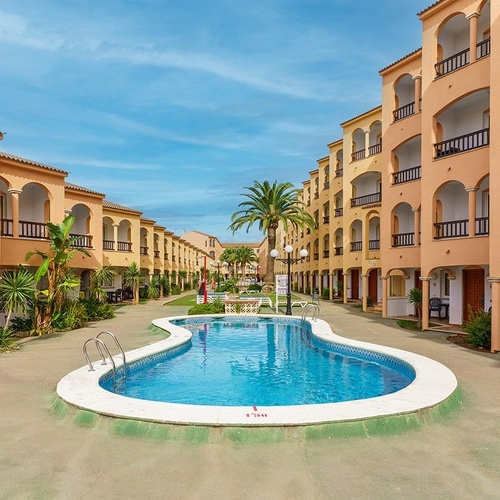 una piscina rodeada de edificios de apartamentos y palmeras