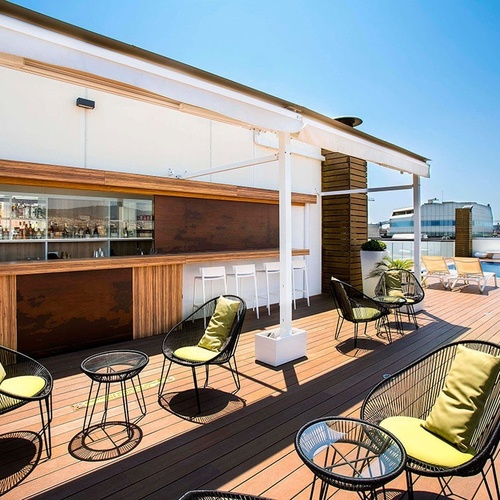 una terraza con sillas y mesas y un bar en el fondo