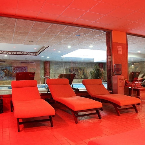 una habitación con sillas rojas y un dispensador de agua