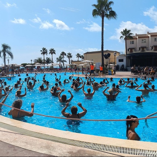 un grupo de personas en una piscina con las manos en el aire