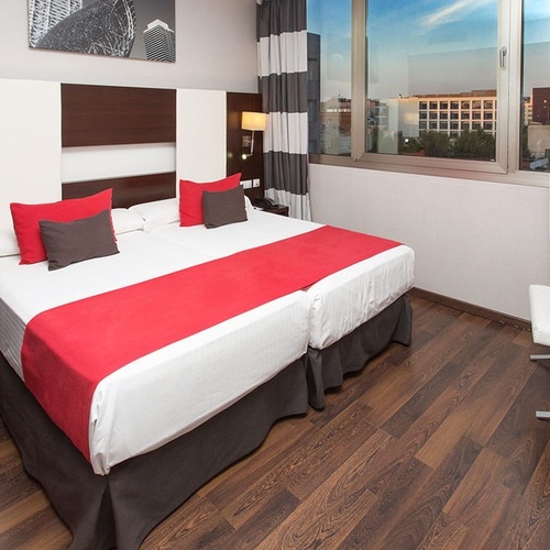 una habitación de hotel con dos camas y una ventana