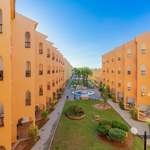 un gran edificio naranja con una piscina en el medio