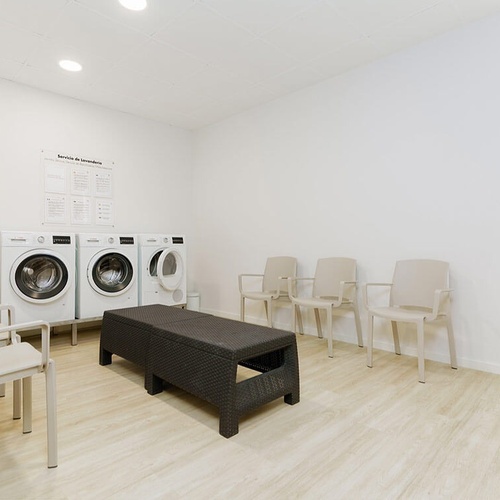 una sala de lavandería con lavadoras y secadoras