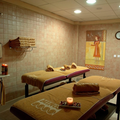 dos camas de masaje en un spa con toallas y velas