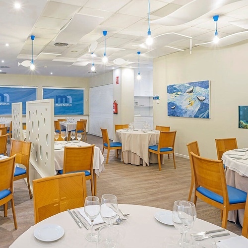 un restaurante con mesas y sillas y un acuario