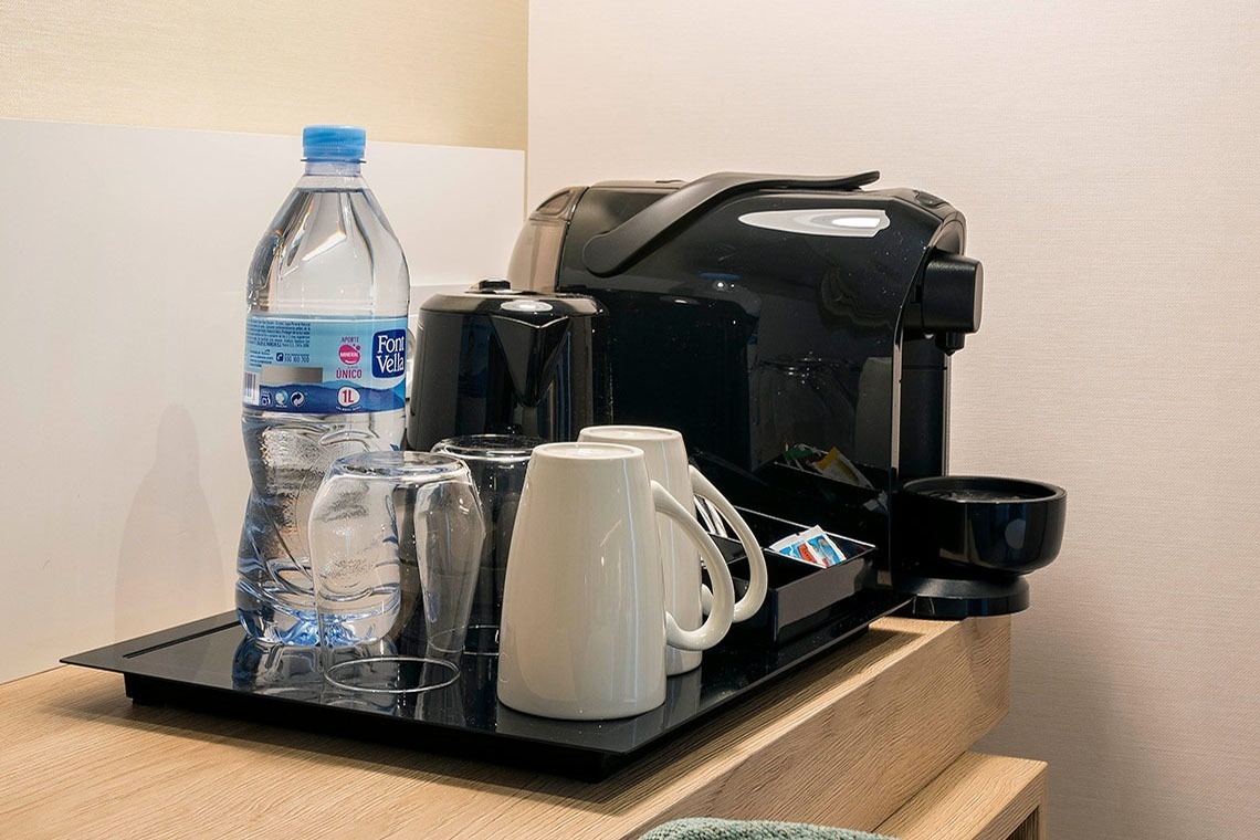 una botella de aquarius junto a vasos y tazas