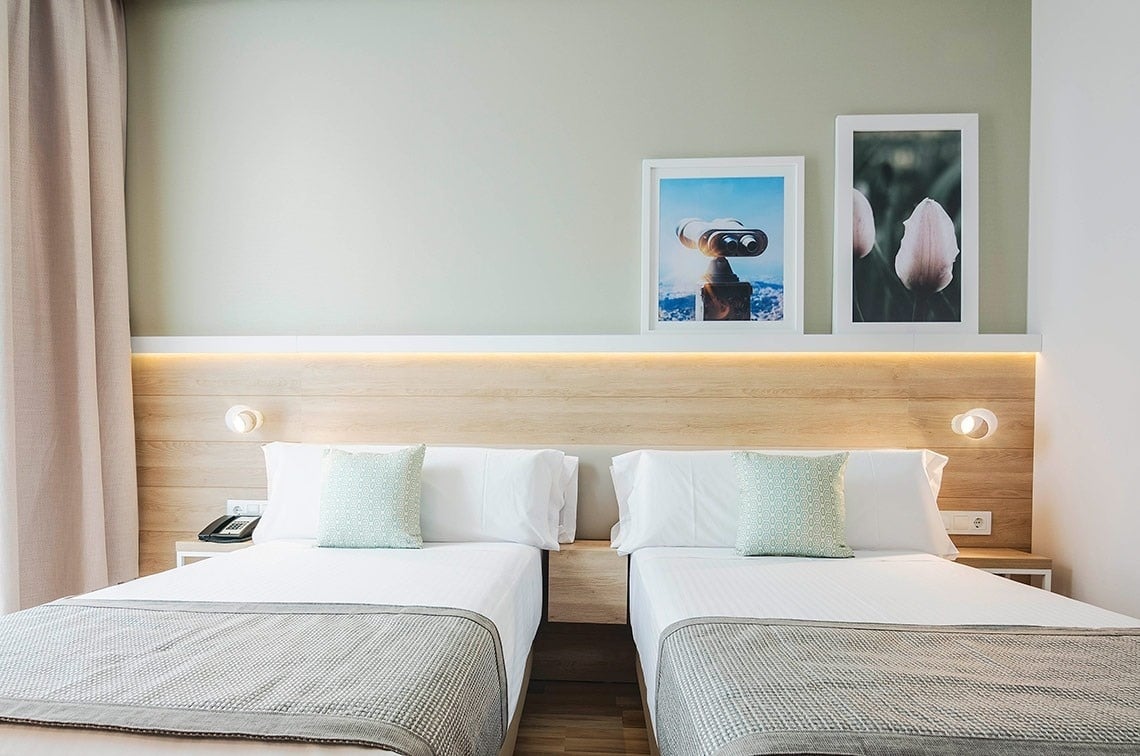 una habitación con dos camas y dos cuadros en la pared