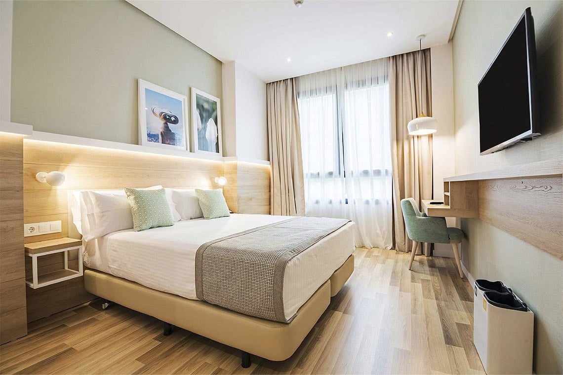 Habitación moderna en ZT Golden Barcelona con cama king y escritorio.
