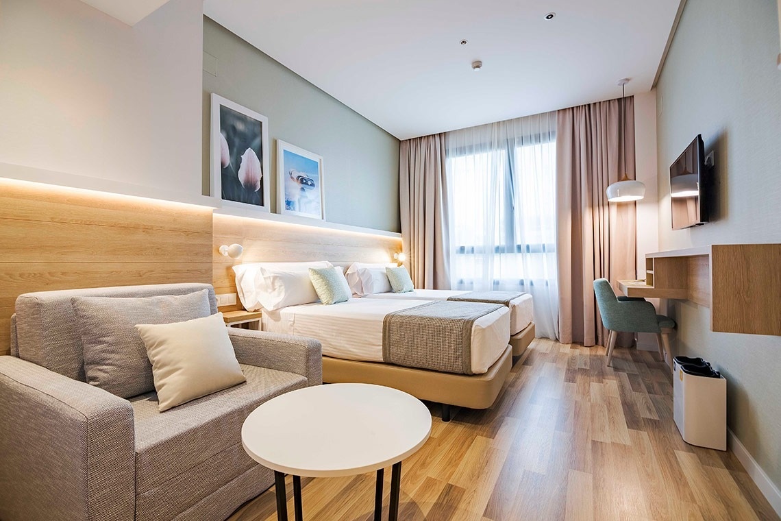 una habitación de hotel con dos camas y una mesa