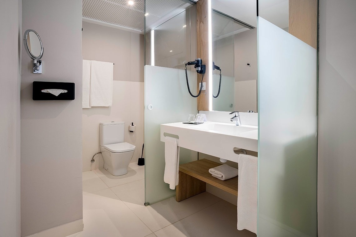 un baño con inodoro , lavabo y espejo