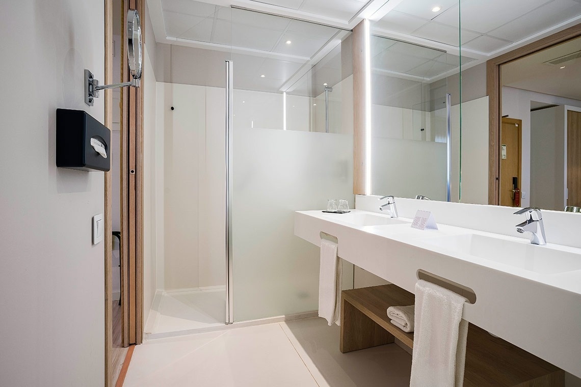 un baño de hotel con dos lavabos y una ducha