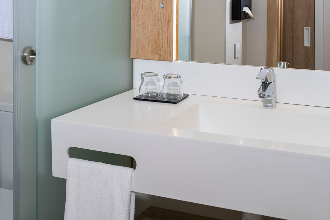 Lavabo moderno con grifo cromado, toalla y vasos. Ideal para tu ZT: Golden Barcelona.