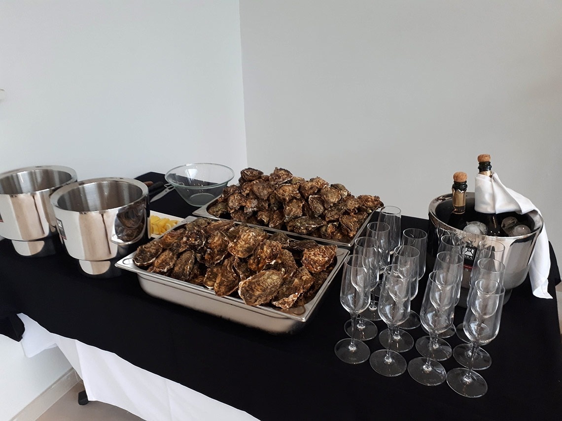 a tray of oysters sits on a table next to a bucket of champagne