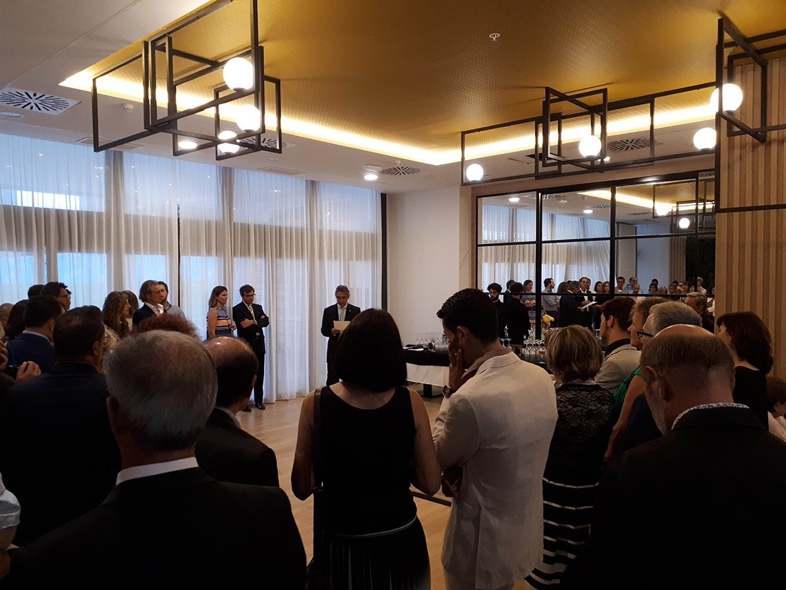 a group of people are gathered in a room with a yellow ceiling
