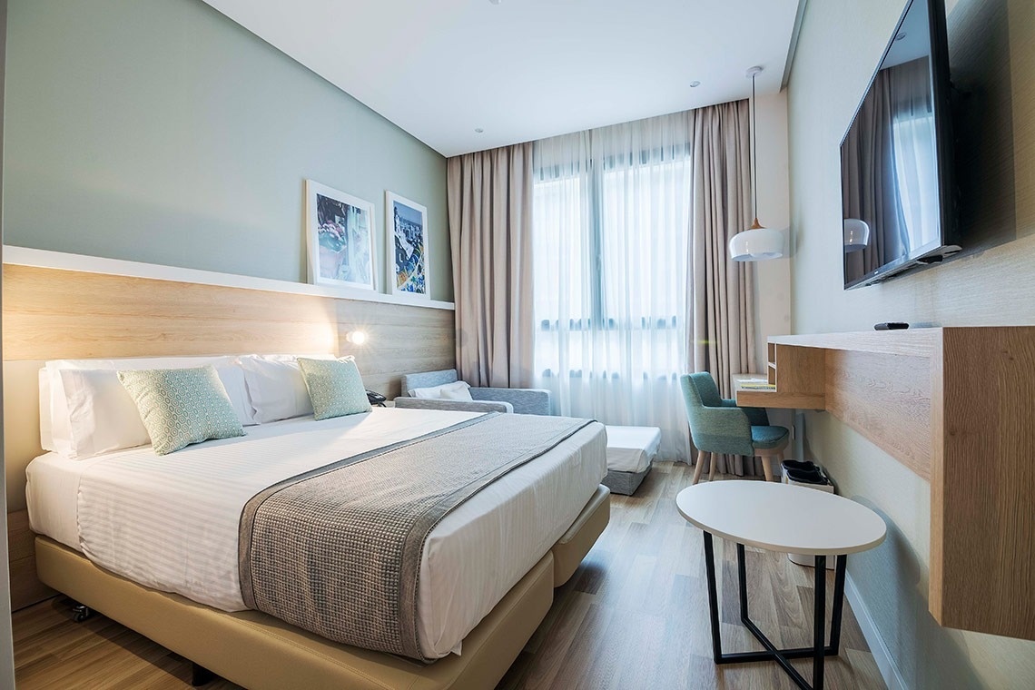 una habitación de hotel con una cama y una televisión