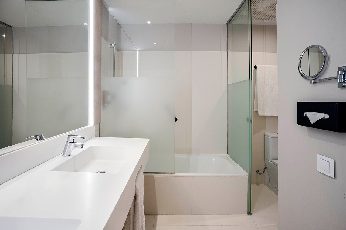 Baño moderno con lavabo, bañera, inodoro y espejo, ideal para ZT: Golden Barcelona.
