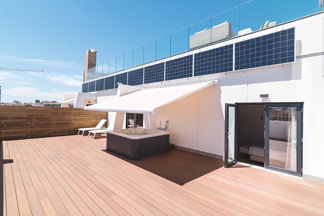 un jacuzzi en una terraza con paneles solares en el techo