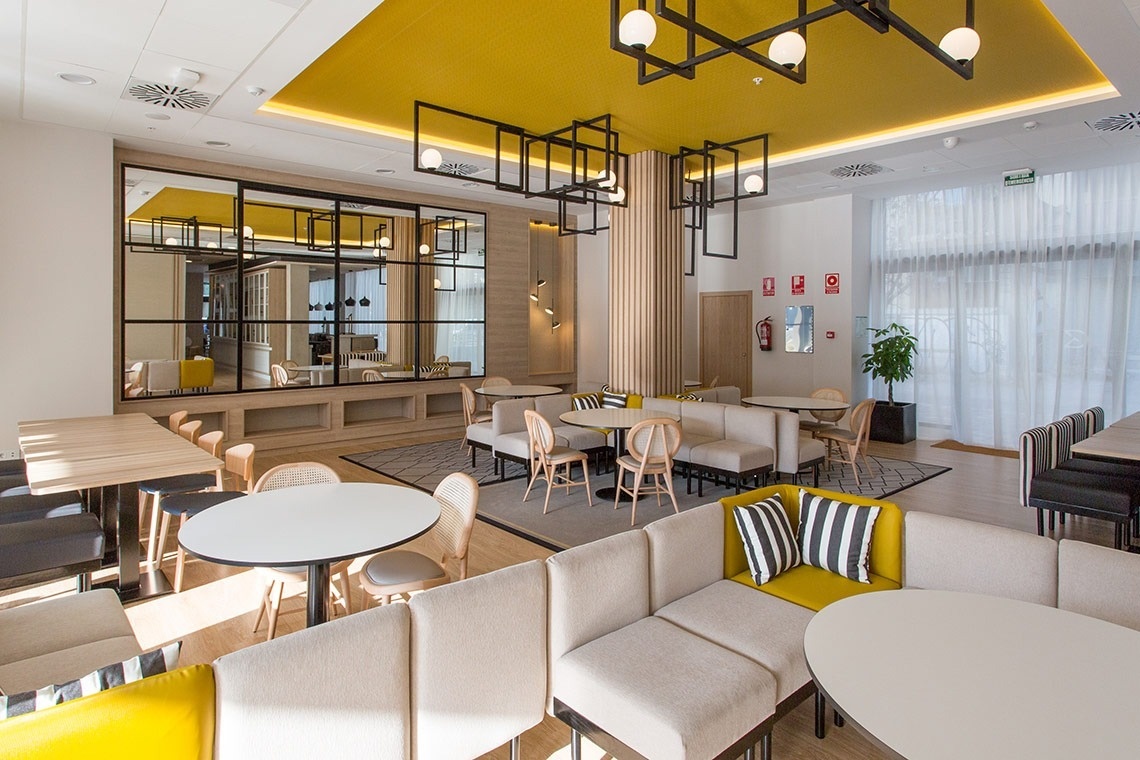 a room with tables and chairs and a fire extinguisher on the wall