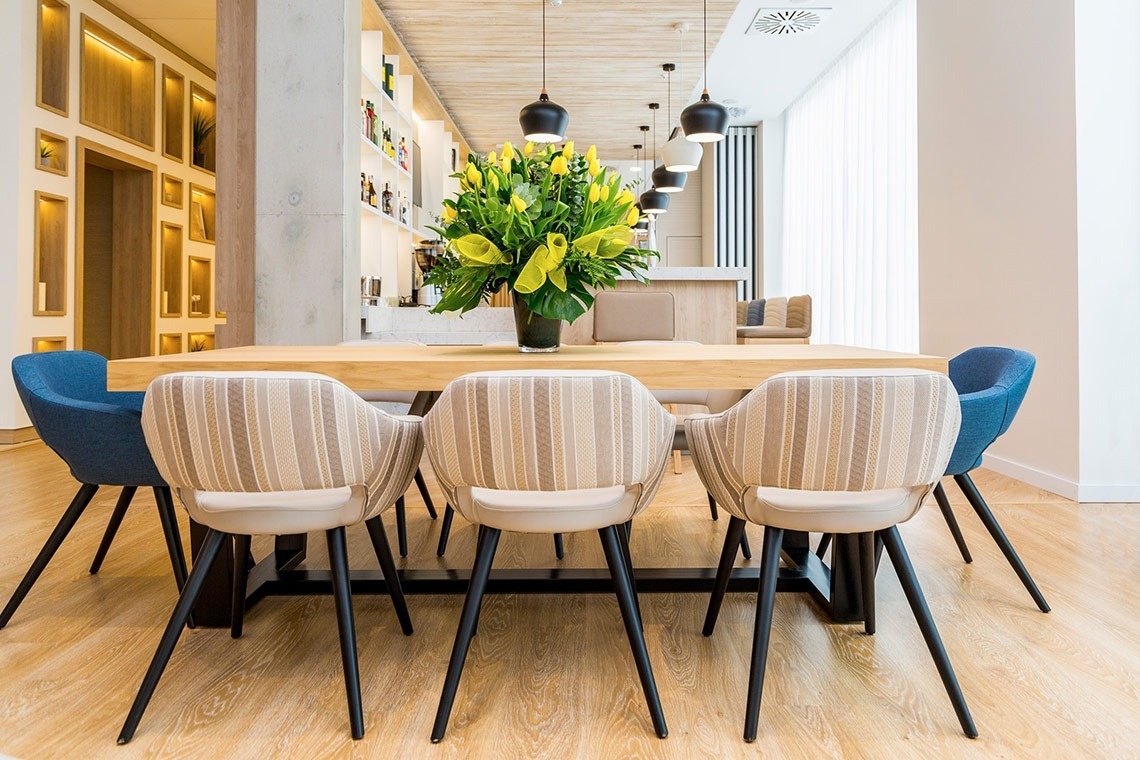 a table with chairs and a vase of flowers on it
