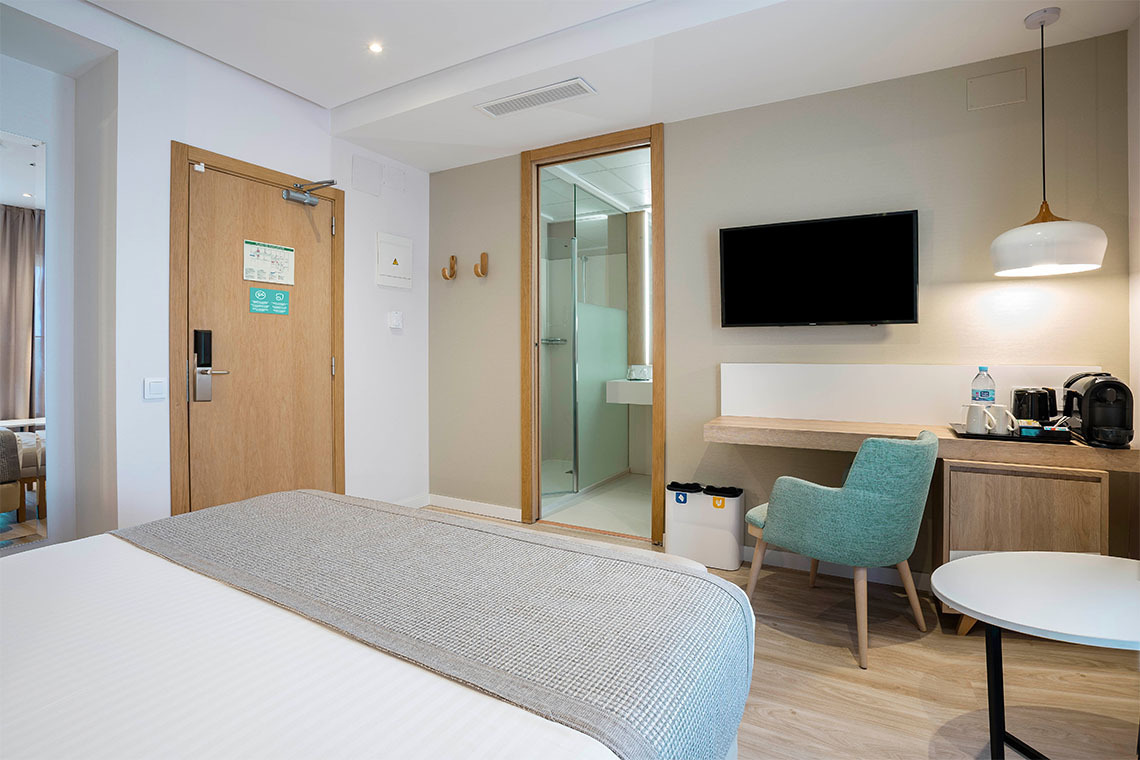 Habitación moderna con cama, escritorio y baño. ZT: Golden Barcelona