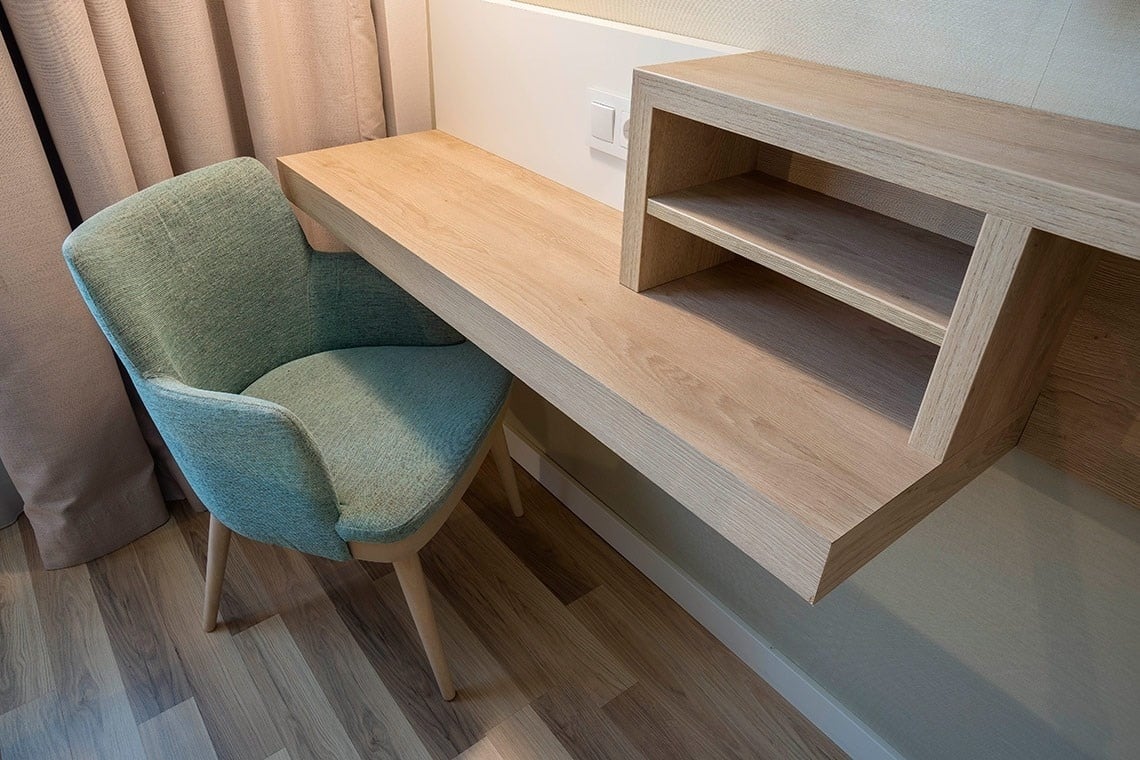 una silla azul está sentada junto a un escritorio de madera