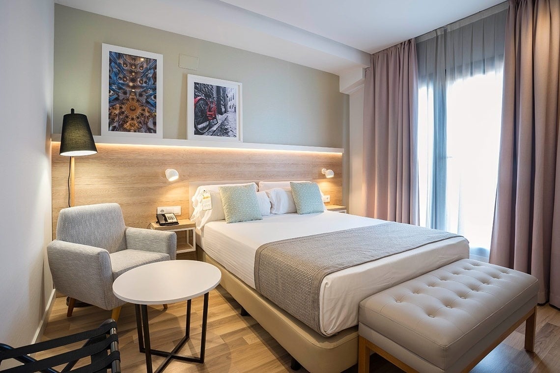 una habitación de hotel con dos camas y una mesa