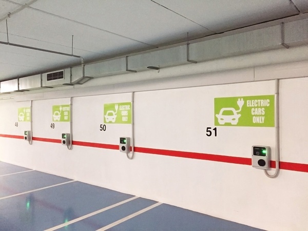 una fila de coches eléctricos están estacionados en un estacionamiento