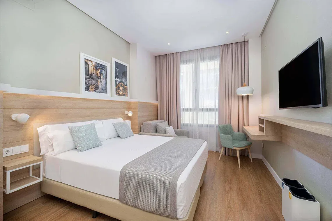 Camera d'albergo moderna ZT Golden Barcelona con letto king e scrivania.