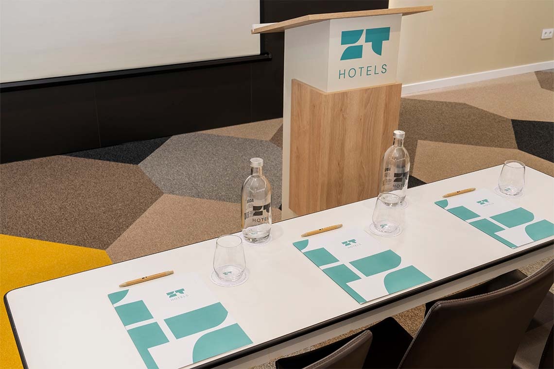 Golden Barcelona conference room setup with water bottles and notes.