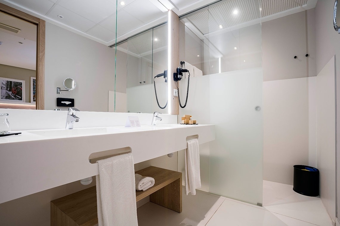 un baño de hotel con dos lavabos y una ducha