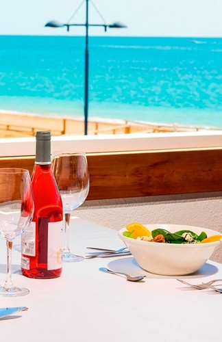un hombre con una camisa blanca con la palabra aida en el pecho está sirviendo a una mujer con un sombrero de paja