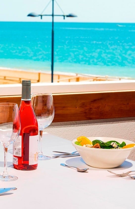 un hombre con una camisa blanca con la palabra aida en el pecho está sirviendo a una mujer con un sombrero de paja