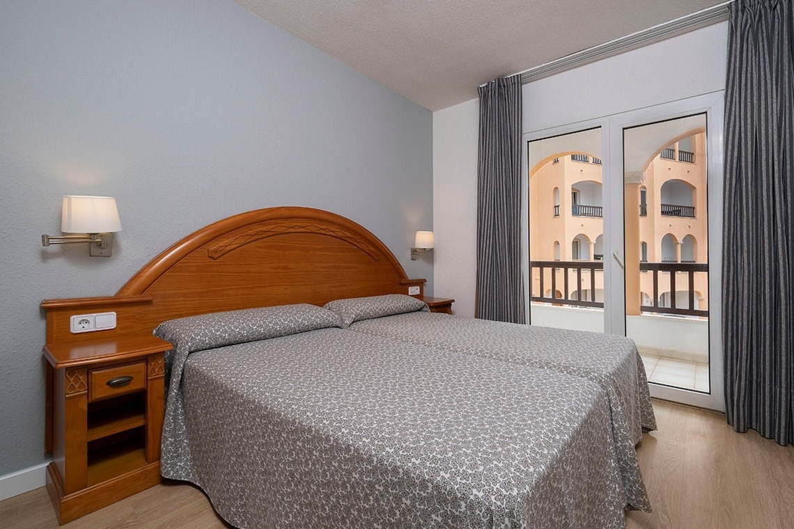 una habitación de hotel con una cama y una ventana