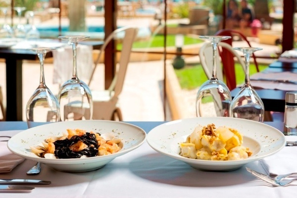 two plates of food on a table with wine glasses