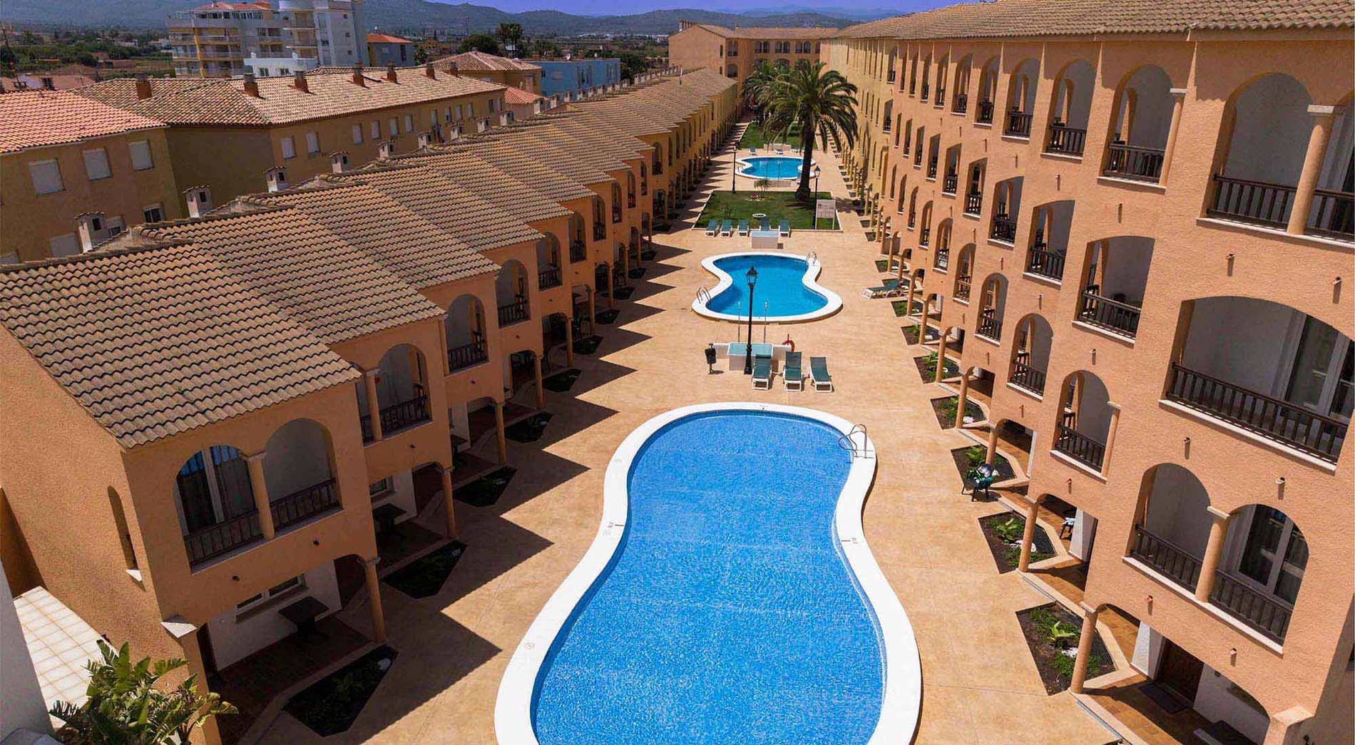 Jardines del Plaza: piscine et appartements de vacances ensoleillés avec balcons et végétation luxuriante.