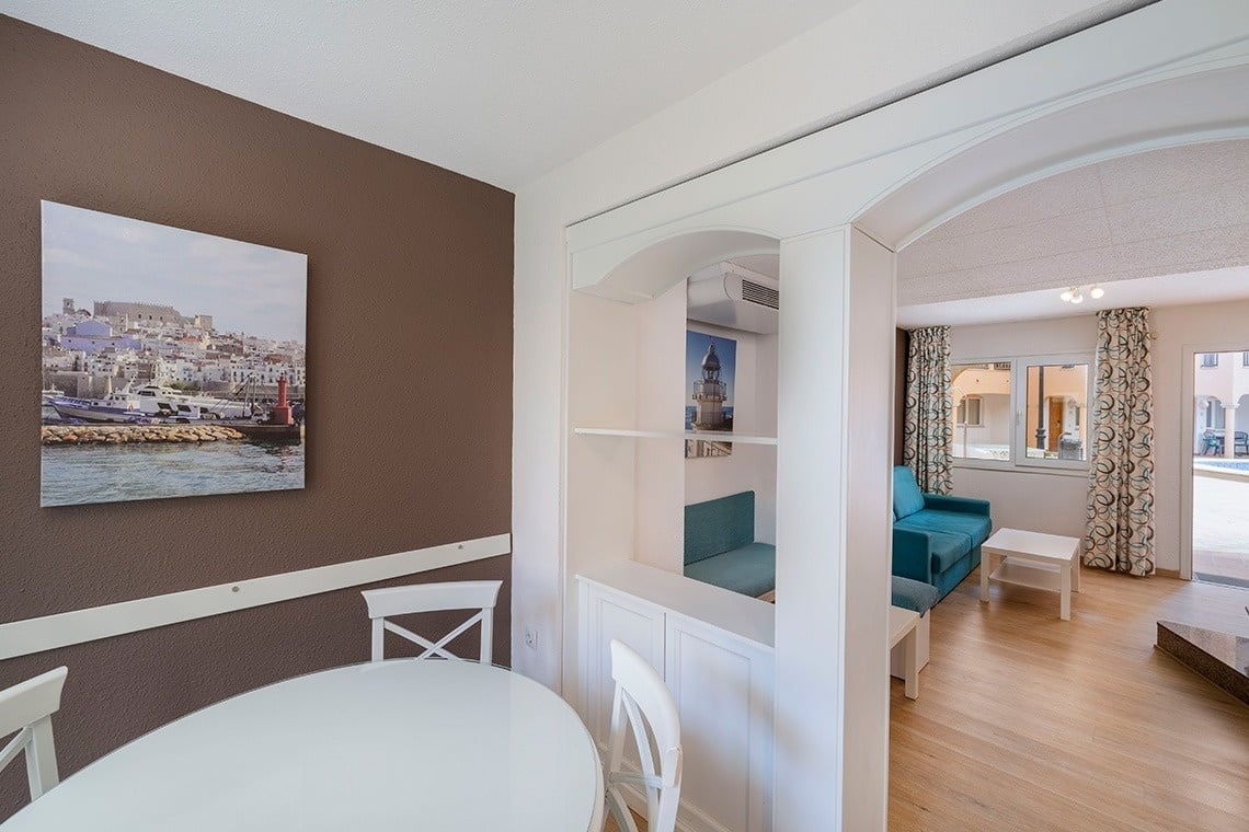 una habitación con una mesa y sillas y una pintura en la pared