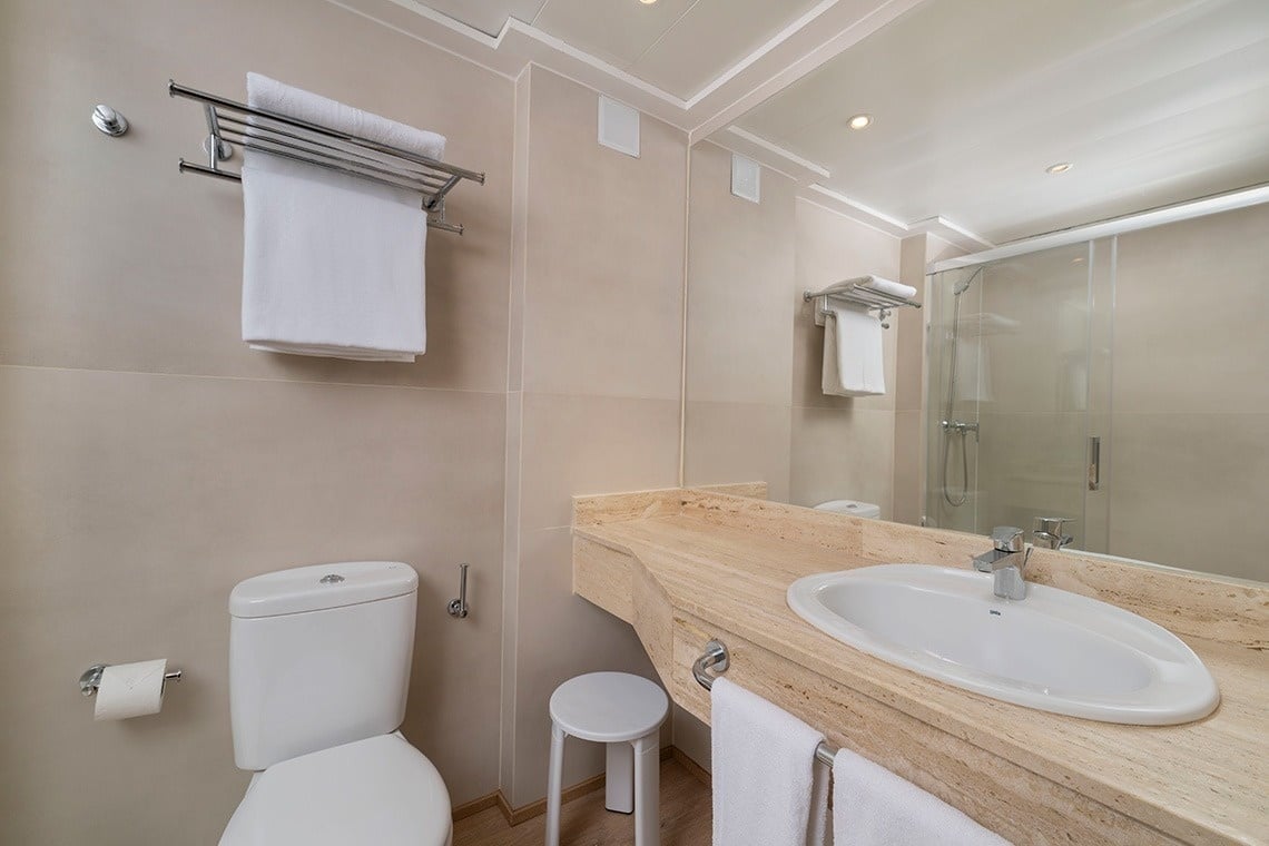 un baño con inodoro , lavabo y espejo