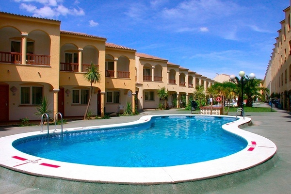 una gran piscina rodeada de edificios y palmeras