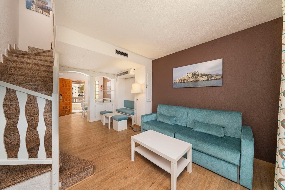 una sala de estar con un sofá azul y una mesa blanca