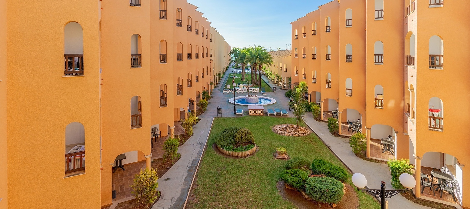 un patio con muebles y sombrillas y un techo camuflado