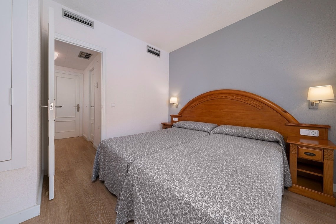 una habitación con una cama y dos mesitas de noche