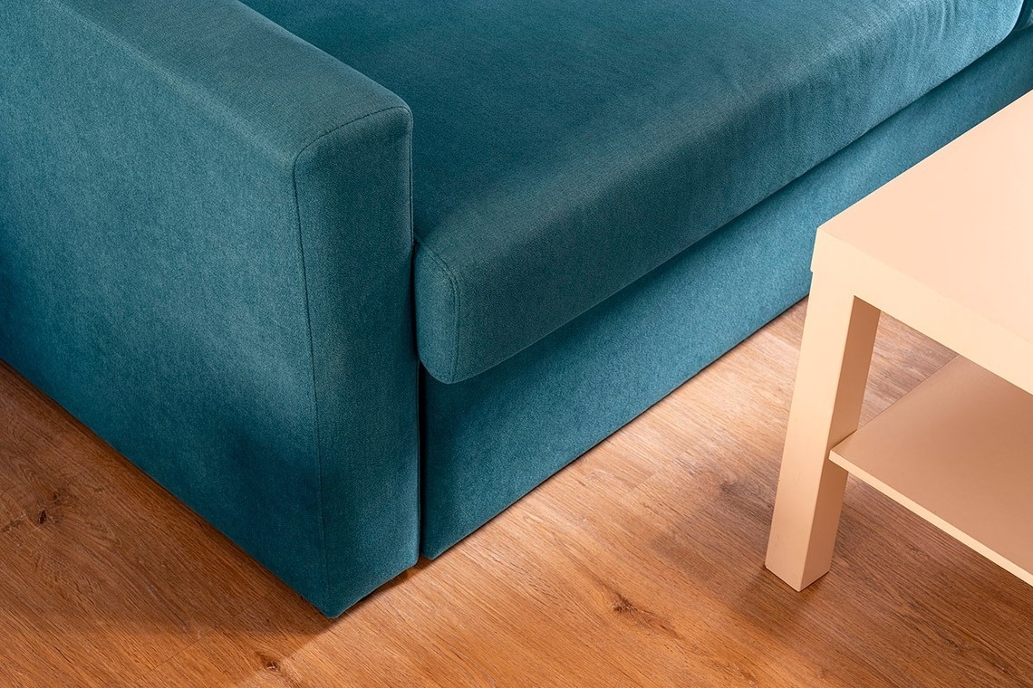 un sofá azul junto a una mesa de madera