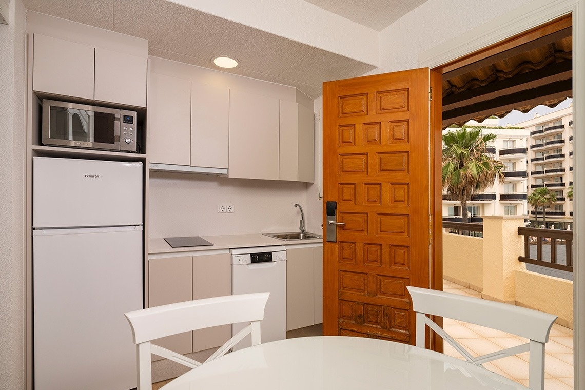 una cocina pequeña con una nevera samsung y un microondas