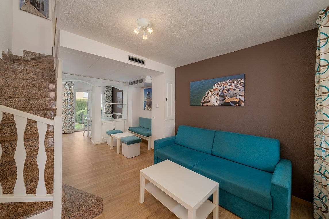 una sala de estar con un sofá azul y una mesa blanca