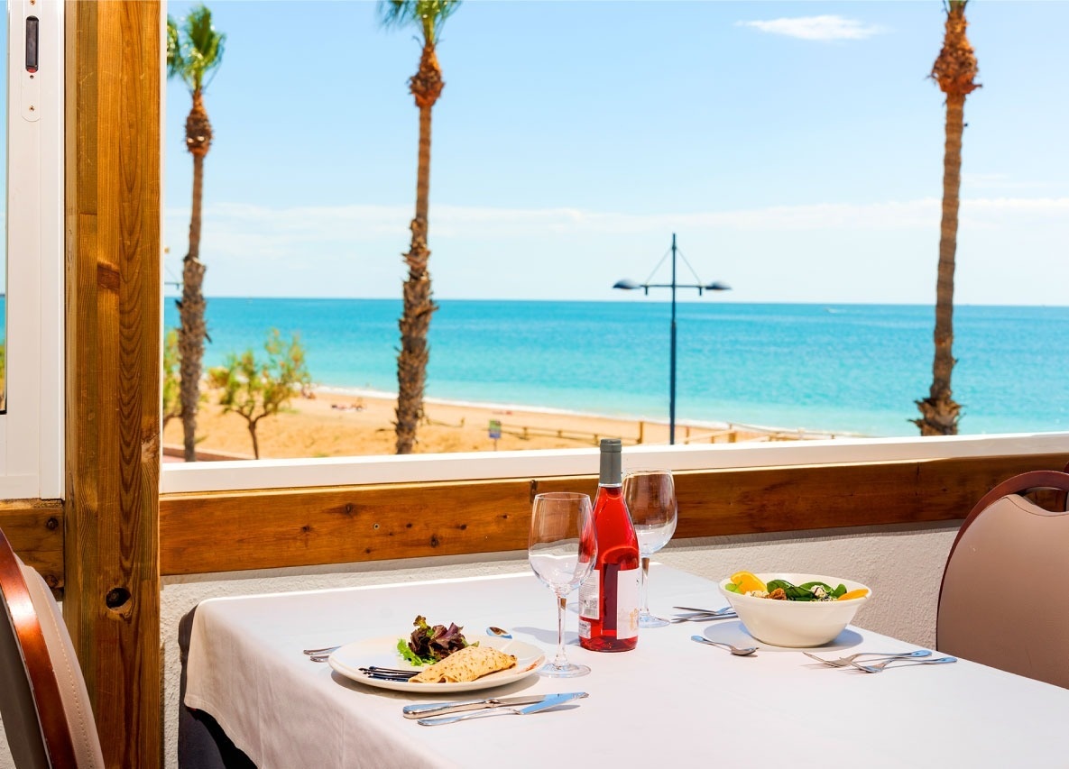 una mesa con un plato de comida y una botella de vino