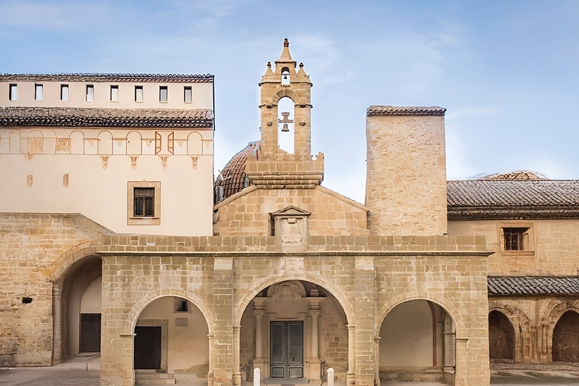 un adorno rojo colgando de una rama de un árbol de navidad cubierto de nieve