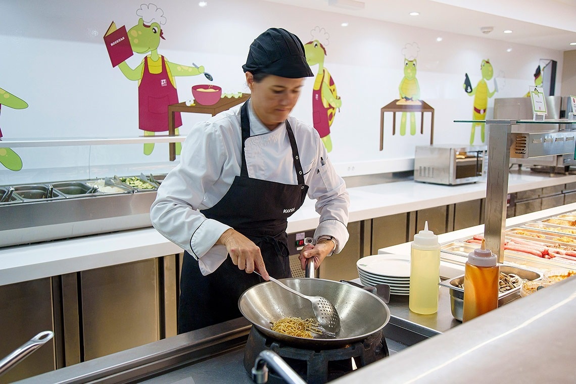 un chef está cocinando comida en una sartén en una cocina